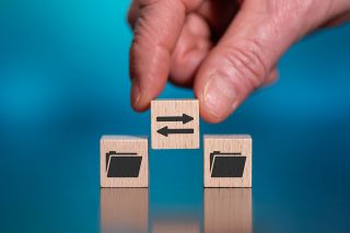 Foto: Hand mit Holzwürfel